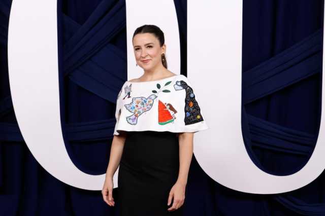 المعلمة راشيل ترتدي فستانا يحمل رسومات أطفال غزة في حفل تكريمي