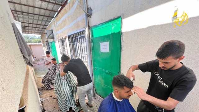 بعد قصف محله.. فلسطيني يحلق للنازحين بالمجان في مركز الإيواء بغزة (صور)