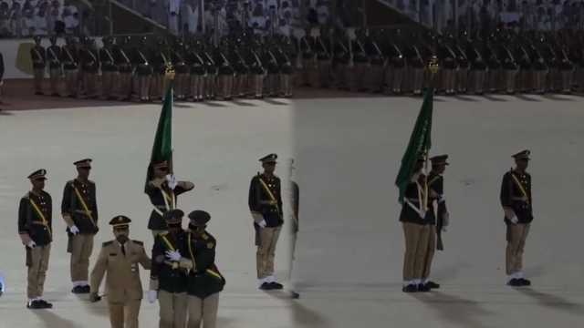 طالب يرفع الراية بيد وبالأخرى يسند زميله المغمى عليه خلال حفل تخريج كلية الملك عبد العزيز الحربية