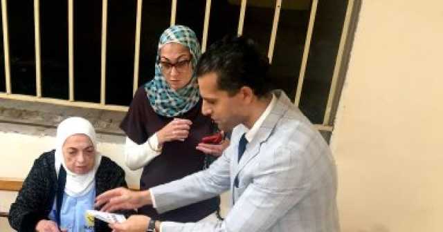 لفتة إنسانية.. رئيس لجنة انتخابية بالعجوزة يخرج لمساعدة سيدة فى التصويت
