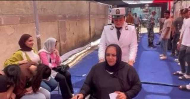 الشرطة النسائية تساعد قعيدة على الوصول إلى لجنتها الانتخابية فى حدائق القبة