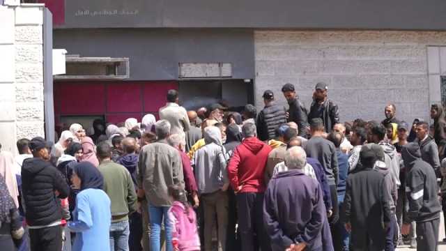 شاهد: لساعات أو أيام.. نازحون ينتظرون في طوابير أمام بنك فلسطين في دير البلح لسحب أموالهم